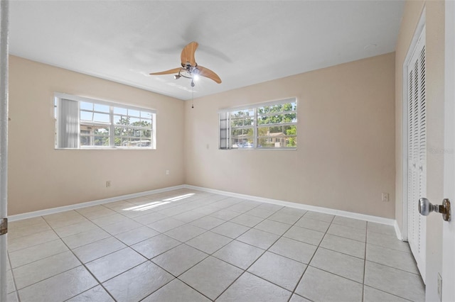 unfurnished room featuring light tile patterned flooring, baseboards, and a ceiling fan