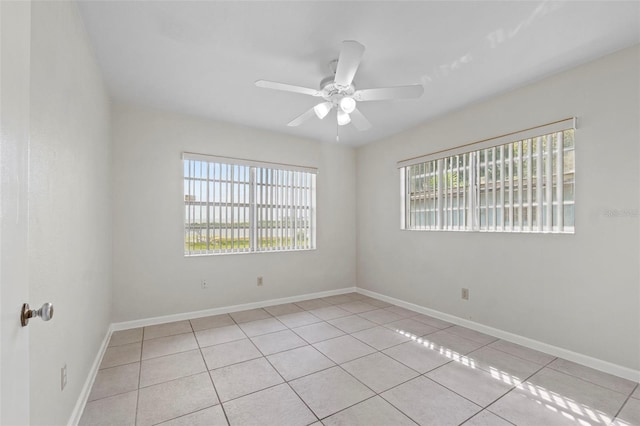 tiled spare room with baseboards and ceiling fan