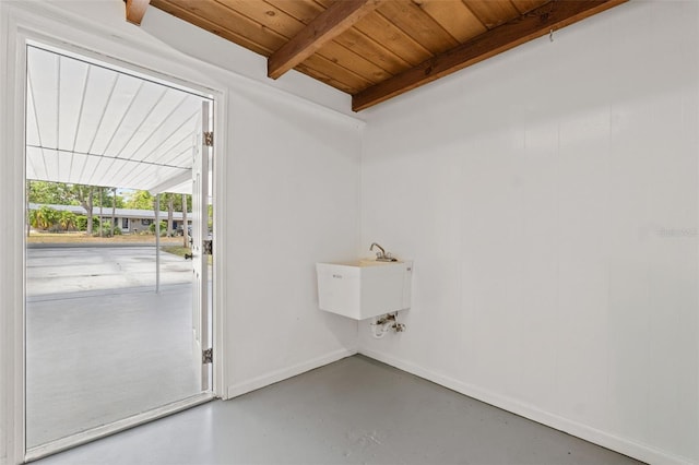 doorway with wooden ceiling, baseboards, a sink, concrete floors, and beam ceiling