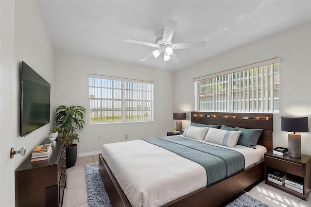 bedroom featuring light tile patterned flooring, baseboards, and a ceiling fan