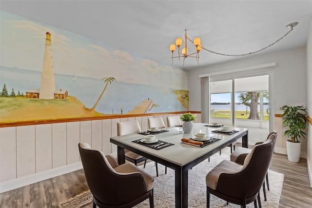 dining area featuring baseboards, an inviting chandelier, and wood finished floors