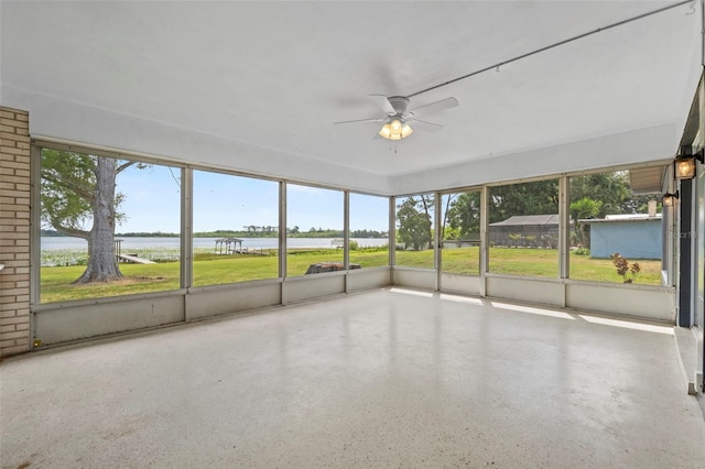 unfurnished sunroom with a water view and a ceiling fan