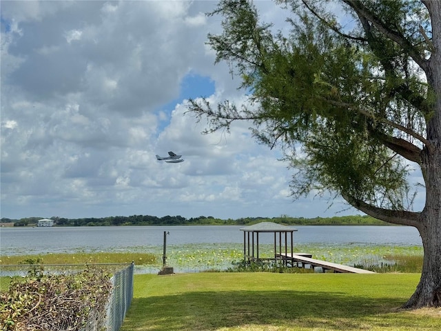 dock area with a water view and a lawn