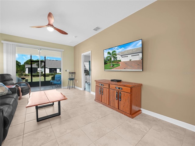 living room with baseboards, ceiling fan, light tile patterned floors, and visible vents