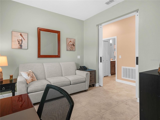 living room featuring light tile patterned floors, baseboards, and visible vents