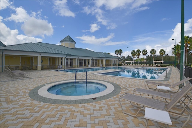 community pool with a patio area and a hot tub