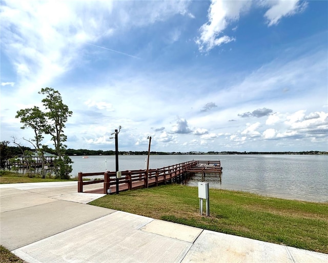 dock area featuring a water view and a lawn