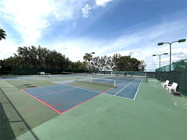 view of tennis court featuring fence and community basketball court