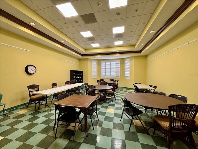 dining room featuring baseboards, tile patterned floors, and a tray ceiling