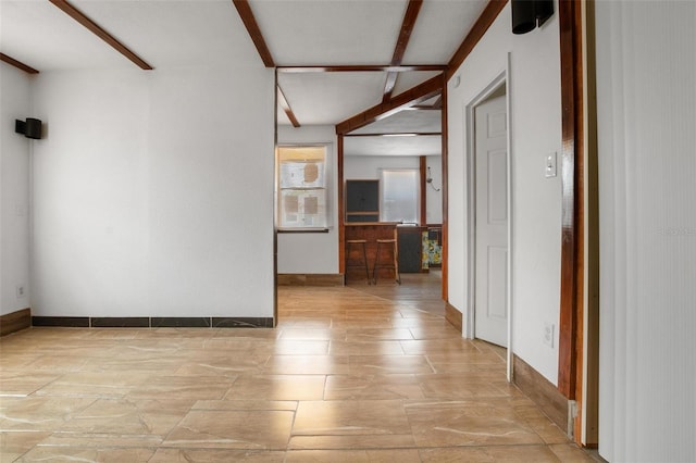 305 Armour Ave, Auburndale, FL 33823 - unfurnished room with baseboards, stone finish floors, and beamed ceiling