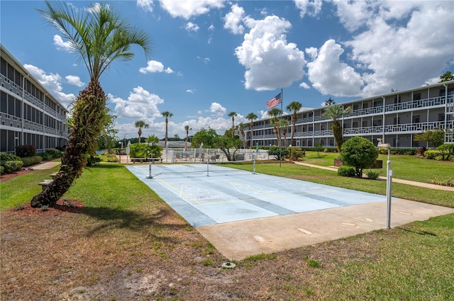 view of property's community with shuffleboard and a yard