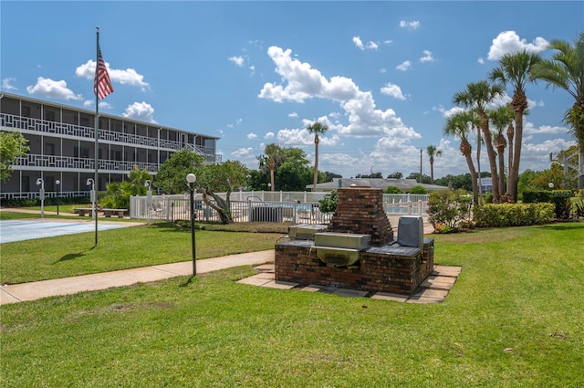 view of community featuring fence and a lawn