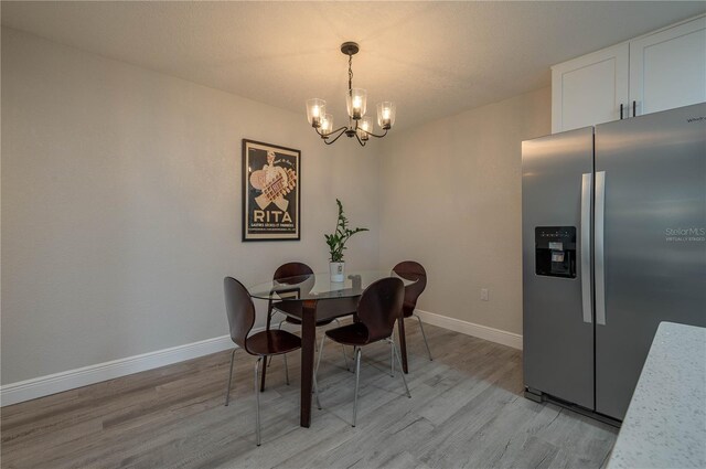 1700 6th St NW Unit C26, Winter Haven, FL 33881 - dining room with light wood-type flooring, a chandelier, and baseboards