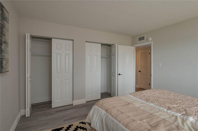 1700 6th St NW Unit C26, Winter Haven, FL 33881 - bedroom with two closets, wood finished floors, and baseboards