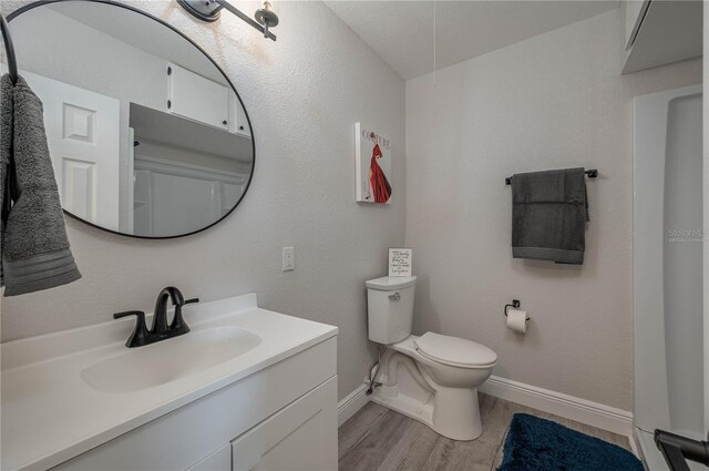 1700 6th St NW Unit C26, Winter Haven, FL 33881 - bathroom featuring baseboards, vanity, wood finished floors, and toilet