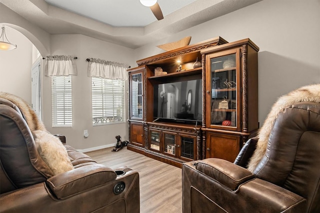 135 Minniehaha Cir, Haines City, FL 33844 - living room with light wood-type flooring, arched walkways, a ceiling fan, and baseboards
