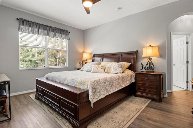 135 Minniehaha Cir, Haines City, FL 33844 - bedroom featuring arched walkways, wood finished floors, baseboards, and a ceiling fan