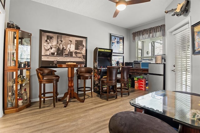 135 Minniehaha Cir, Haines City, FL 33844 - bar area with wood finished floors, ceiling fan, and freestanding refrigerator