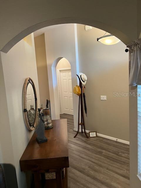 135 Minniehaha Cir, Haines City, FL 33844 - corridor featuring dark wood-style flooring, arched walkways, and baseboards