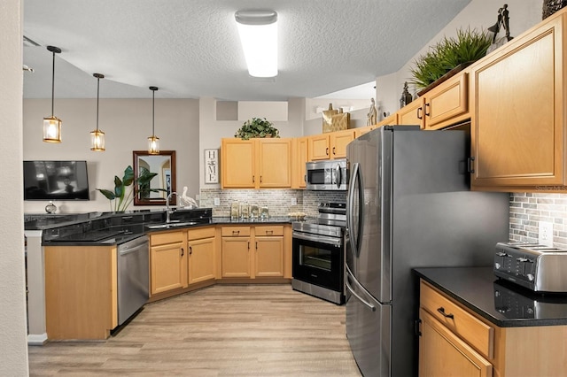 135 Minniehaha Cir, Haines City, FL 33844 - kitchen with stainless steel appliances, a textured ceiling, light wood-style flooring, a peninsula, and backsplash