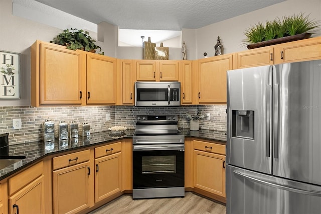 135 Minniehaha Cir, Haines City, FL 33844 - kitchen featuring appliances with stainless steel finishes, light wood finished floors, tasteful backsplash, light brown cabinets, and a textured ceiling