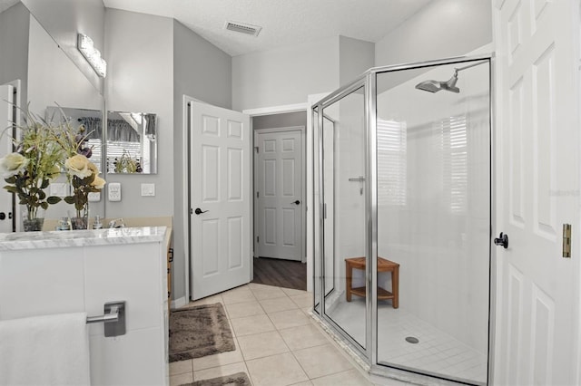 135 Minniehaha Cir, Haines City, FL 33844 - bathroom featuring a shower stall, vanity, tile patterned floors, and a textured ceiling