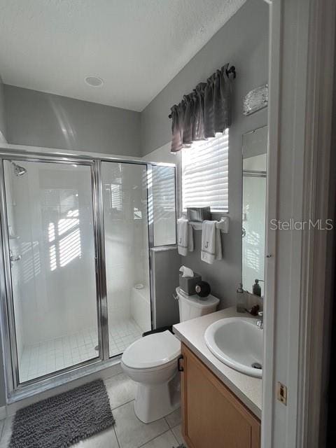 135 Minniehaha Cir, Haines City, FL 33844 - full bathroom featuring vanity, a shower stall, toilet, tile patterned flooring, and a textured ceiling
