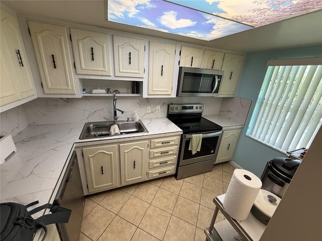 333 Lake Howard Dr NW Unit 103C, Winter Haven, FL 33880 - kitchen featuring stainless steel appliances, a sink, backsplash, light stone counters, and light tile patterned flooring