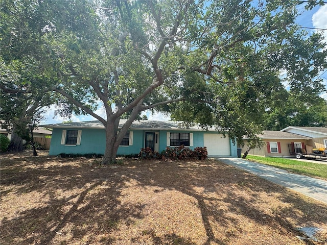 ranch-style house with concrete driveway and a garage