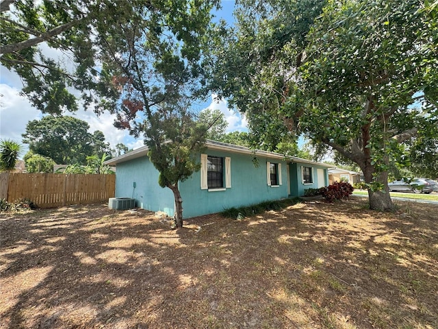 view of side of property featuring fence and central air condition unit