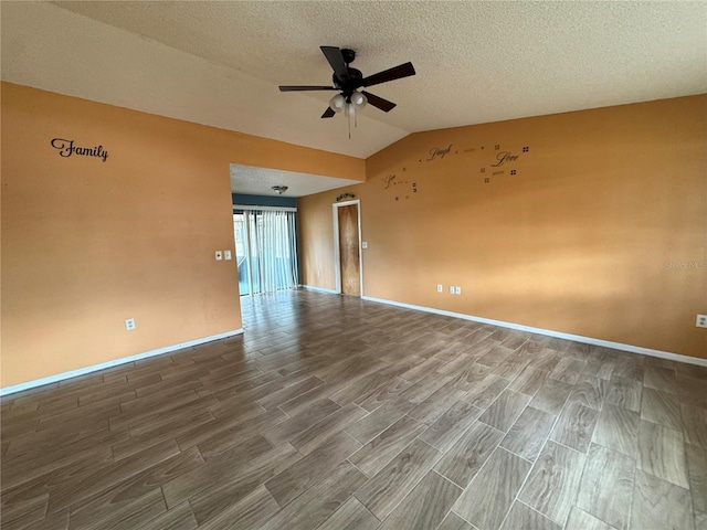 empty room featuring wood finished floors, a ceiling fan, vaulted ceiling, baseboards, and a textured ceiling