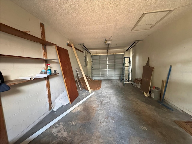 garage with a garage door opener and concrete block wall