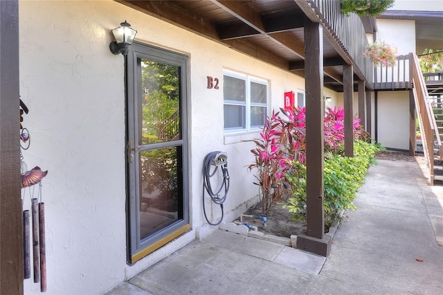doorway to property featuring stucco siding