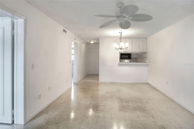 unfurnished living room featuring a ceiling fan, a chandelier, and baseboards