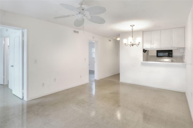 unfurnished living room featuring a chandelier, a ceiling fan, and baseboards