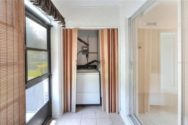 laundry area featuring washer / clothes dryer and light tile patterned floors