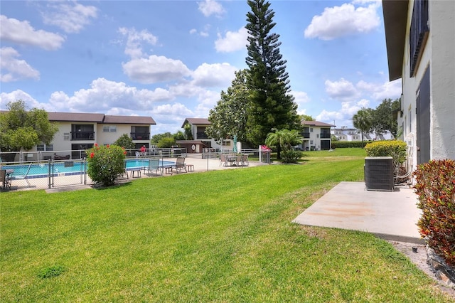 view of yard with central AC unit, a patio, and a community pool