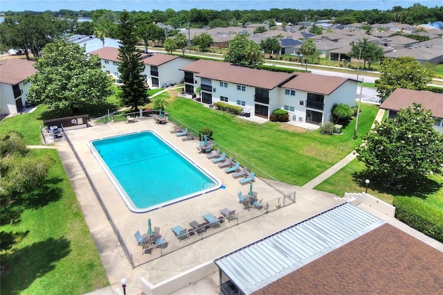 community pool featuring a residential view and a lawn