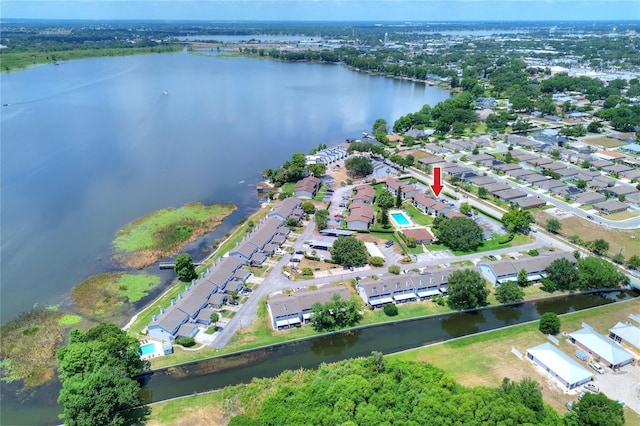 aerial view of property's location featuring a nearby body of water and nearby suburban area