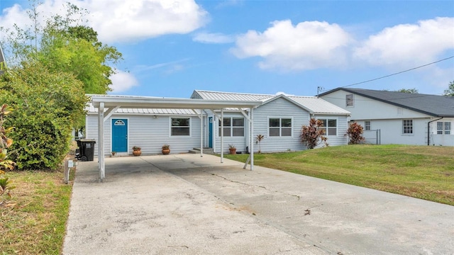900 Lake Jessie Dr, Winter Haven, FL 33881 - ranch-style home with driveway, a front yard, metal roof, and a detached carport