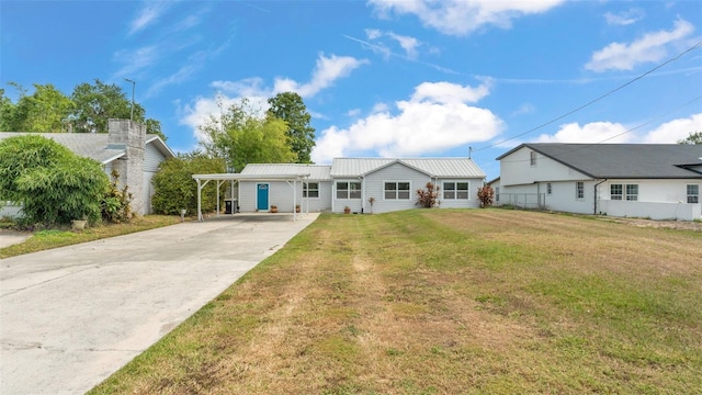 900 Lake Jessie Dr, Winter Haven, FL 33881 - view of front of home with driveway, a front lawn, an attached carport, and metal roof
