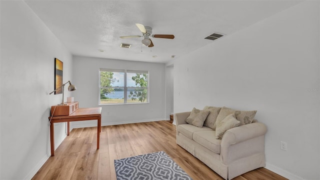 900 Lake Jessie Dr, Winter Haven, FL 33881 - living area with light wood-style floors, a ceiling fan, and baseboards