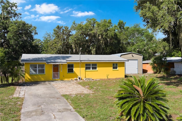 1163 Lake Dr, Lake Wales, FL 33859 - ranch-style home featuring a front lawn, driveway, and an outbuilding