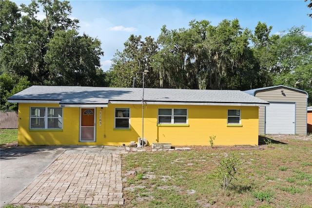 1163 Lake Dr, Lake Wales, FL 33859 - view of front of home with an outdoor structure, view of scattered trees, a storage shed, and roof with shingles