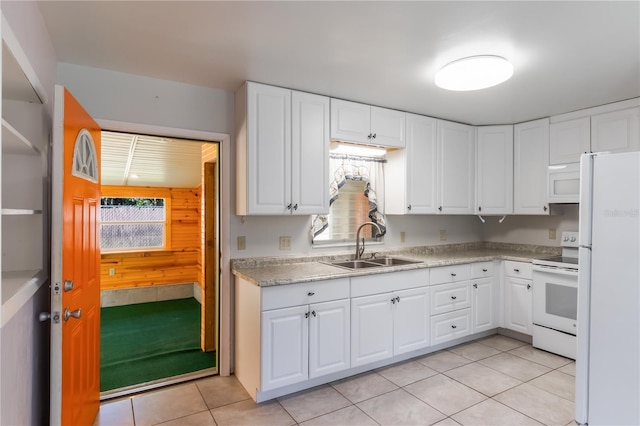 1163 Lake Dr, Lake Wales, FL 33859 - kitchen with white appliances, a sink, light tile patterned floors, light countertops, and white cabinetry