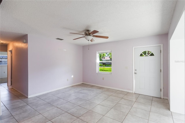 1163 Lake Dr, Lake Wales, FL 33859 - foyer entrance featuring a ceiling fan, light tile patterned floors, a textured ceiling, and baseboards