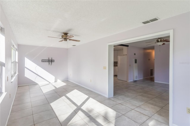 1163 Lake Dr, Lake Wales, FL 33859 - spare room featuring a ceiling fan, light tile patterned floors, a textured ceiling, and baseboards