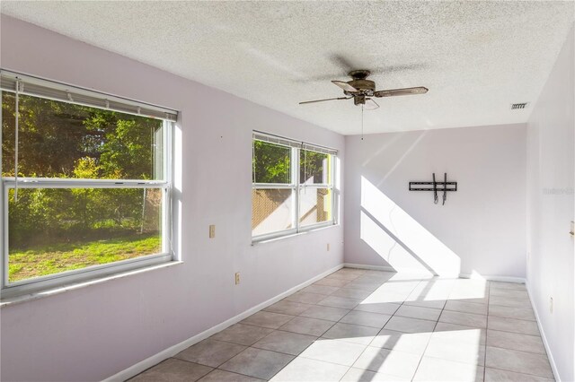 1163 Lake Dr, Lake Wales, FL 33859 - unfurnished room with ceiling fan, tile patterned floors, baseboards, and a textured ceiling