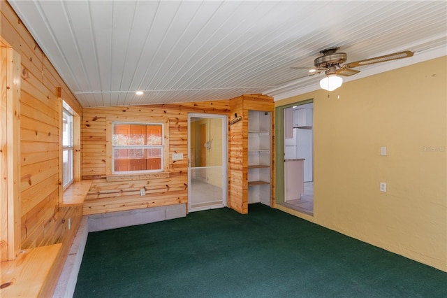 1163 Lake Dr, Lake Wales, FL 33859 - empty room with wooden walls, carpet, and a ceiling fan