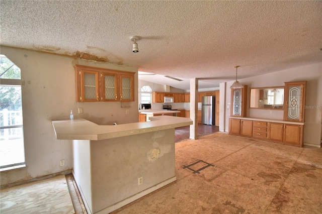 1294 1/2 38th St NW, Winter Haven, FL 33881 - kitchen featuring appliances with stainless steel finishes, brown cabinets, light countertops, a textured ceiling, and plenty of natural light